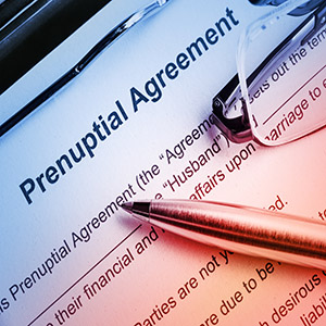Close-up of a Prenuptial Agreement document, with a pen and reading glasses resting on it